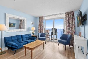 a living room with a blue couch and a view of the ocean at Roxanne Towers Penthouse 6 - Oceanfront in Myrtle Beach