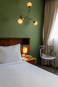 a bedroom with a bed and a chair and a lamp at Flor de Mayo Hotel & Restaurant in Cuernavaca +43 photos