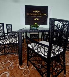 a black table and chairs with a sign on the wall at CS HARZgeflüster-Das Familienhotel in Thale