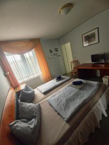 a bedroom with two beds and a desk and a window at CS HARZgeflüster-Das Familienhotel in Thale