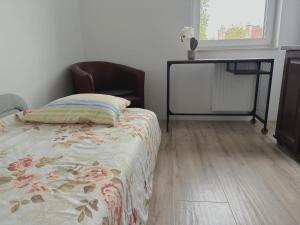 a bedroom with a bed and a table and a window at Mikołowska 9 pokój in Gliwice