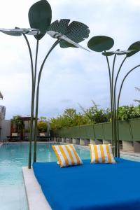 a pool with two pillows on a blue floor next to two lights at Flor de Mayo Hotel & Restaurant in Cuernavaca