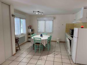a kitchen with a table and chairs and a refrigerator at Pyrenees family T3 in Aulus-les-Bains