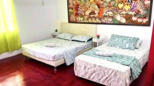 two beds and a couch in a room at BlackSands Guests House Langkawi in Huma