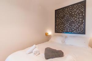 a white bed with a blanket on top of it at Le Jardin des Alpilles in Eyguières +15 photos