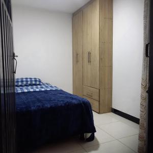 Un dormitorio con una cama y un armario de madera. en Confortable Apartamento Norte de Popayán, en Popayán
