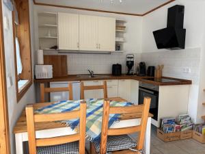 a kitchen with a table and chairs and a sink at Toms Stuga Ferienwohnung in Schöneiche