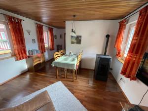 a dining room with a table and a stove at Ferienwohnung Menz - Alte Mühle - mit Milseburgblick und Gartenpool in Hofbieber