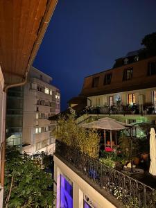 a balcony of a building with an umbrella and plants at appartement confortable en centre ville in Montreux