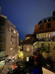 a view of two buildings in a city at night at appartement confortable en centre ville in Montreux +4 photos