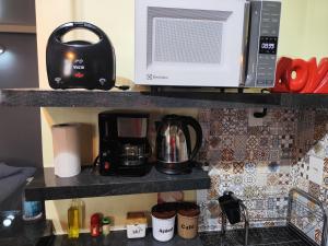 a kitchen counter with a microwave and a coffee maker at Pousada Confort in Sao Paulo +5 photos