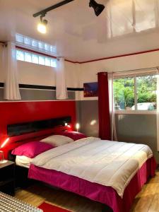 a bedroom with a large bed with a red headboard at Studio king-size bed, all comfort in Balaté in Saint-Laurent du Maroni
