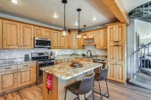 a kitchen with wooden cabinets and a island with chairs at The View at Mountain Retreat By Red Rocks and Golden in Evergreen