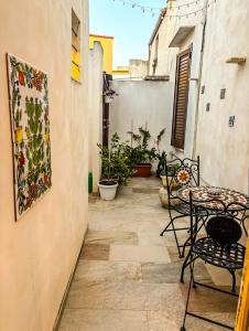 a patio with a table and chairs and a painting on the wall at Il fico d'india in Marsala
