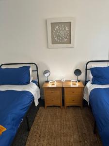a room with two beds and a night stand with two lamps at Contractor friendly-2 bd-Private Parking-Sleeps 3 in Llandeilo