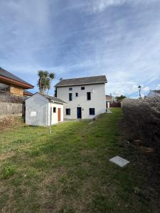 een wit huis in een veld met een tuin bij Casa Chita in Tapia de Casariego