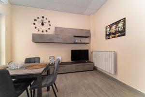 a dining room with a table and a clock on the wall at Casa Meme - Trilocale elegante in Grugliasco