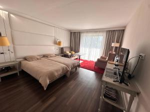 Un dormitorio con una cama grande y una sala de estar. en Ocean et Golf, en Anglet