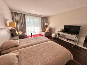Habitación de hotel con dormitorio con cama y piano en Ocean et Golf, en Anglet