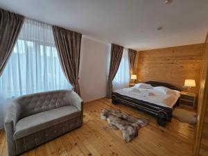 a bedroom with a bed and a couch at Pensiunea Ana Maria Durau in Durau
