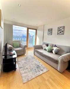 a living room with a couch and a table at Leeds Dock Apartment in Hunslet