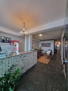 a lobby with a brick counter and a dining room at Verde Mar Pousada in João Pessoa +19 photos