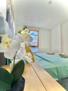 a room with a bed and a flower in a vase at Leeds Dock Apartment in Hunslet