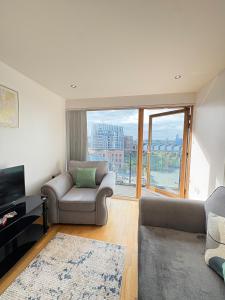 a living room with a couch and a tv and a window at Leeds Dock Apartment in Hunslet +24 photos