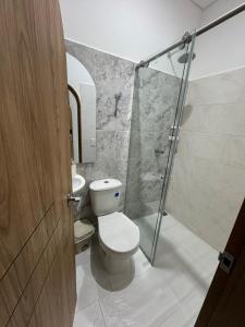 Un baño con inodoro y ducha de cristal. en Habitaciones en Doradal 204, en Doradal