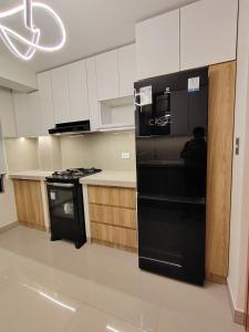 une cuisine avec un réfrigérateur noir et une cuisinière dans l'établissement chiclayo, à La Victoria