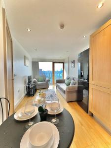 a kitchen and living room with a table and chairs at Leeds Dock Apartment in Hunslet