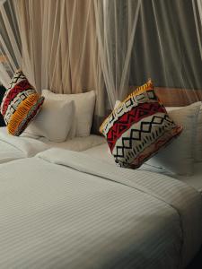 una cama con dos almohadas encima en Safari Homes Tz, en Arusha 47 fotos más