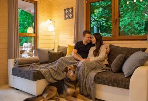 a man and woman sitting on a couch with a dog at Sielankownia in Radków