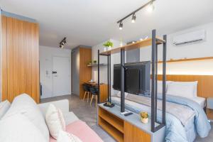a bedroom with a bed with a large tv at Studio Completo para 5 Pessoas Com Garagem-EIX0505 in Curitiba