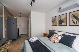 ein Schlafzimmer mit einem Bett mit blauen Kissen in der Unterkunft Studio Completo no Eixo - EIX0507 in Curitiba