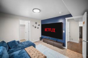 a living room with a blue couch and a television at Charming Family Stay w Arcade Theatre Ski Haven Walking trails and river walk in backyard in Ashford Acres