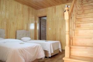 two beds in a room with wooden walls at Ataköy Otel Cafe Restaurant in Çaykara