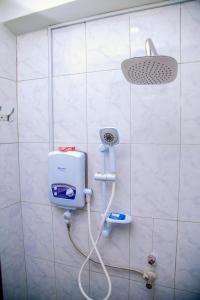 a shower in a bathroom with a hair dryer at Blaize Affaire Apartments in Kampala +32 photos