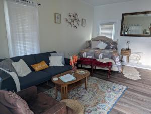 a living room with a blue couch and a table at Cozy, Cute, Private Ozark Suite 5 Mins to Hospital in Ozark