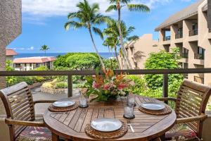 a wooden table on a balcony with a view of the ocean at Kona Pacific E630 in Kailua-Kona
