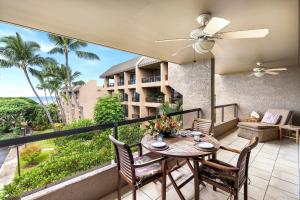 a balcony with a table and chairs and a building at Kona Pacific E630 in Kailua-Kona