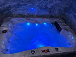 a jacuzzi tub in a cave with blue lights at Raj in Subotica