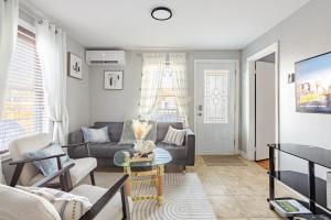 ein Wohnzimmer mit Couch und Tisch in der Unterkunft Grande maison moderne 4 chambres - Spa Jaccuzi, Jardin & Parking gratuit - Idéale Familles et groupes in Saint-Jean-sur-Richelieu