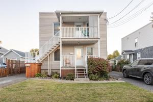 ein Haus mit einer Treppe und einem in der Einfahrt geparkten Auto in der Unterkunft Grande maison moderne 4 chambres - Spa Jaccuzi, Jardin & Parking gratuit - Idéale Familles et groupes in Saint-Jean-sur-Richelieu