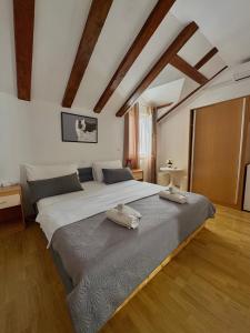 a large bed in a room with wooden floors at Apartment Boras Lux in Cavtat