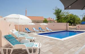 a pool with chairs and umbrellas next to a swimming pool at House Dragica in Imotski