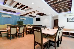 Un comedor con mesas y sillas de madera. en Townhouse New Digha Formerly Hotel Coral, en New Digha 29 fotos más