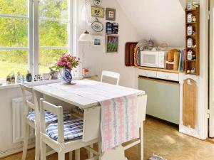 a kitchen with a table with a vase of flowers on it at 6 person holiday home in Ingatorp in Ingatorp