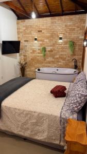 a bedroom with a large bed and a bath tub at Riquezas de Lavras Novas - Chalé Diamante in Lavras Novas