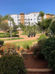 a park with a park bench and some flowers at Mansouria résidence al Kawtar Mohammedia in Mohammedia